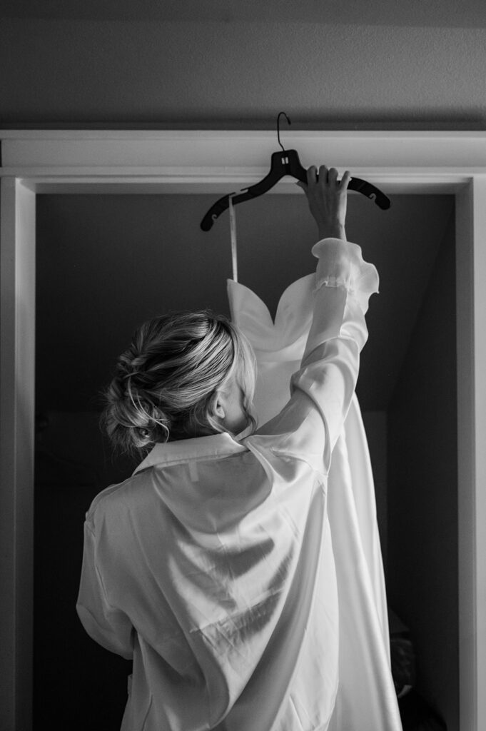 bride reaching up to unhook her wedding dress