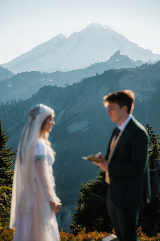 couple reading their vows during their elopement at Artist Point with views of Mount Baker in the background