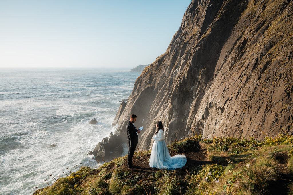couple reading their vows during a vow renewal on the Oregon coast at elk flats