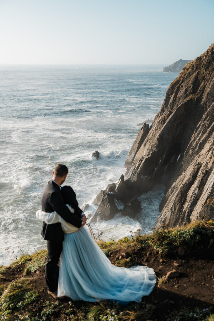 bride and groom watching the sunset at elk flats during their elopement day on the Oregon coast 