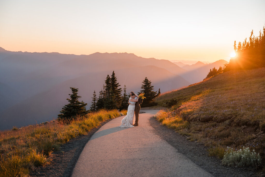 couple embracing while watching the sunset on their hurricane ridge elopement day in olympic national park 