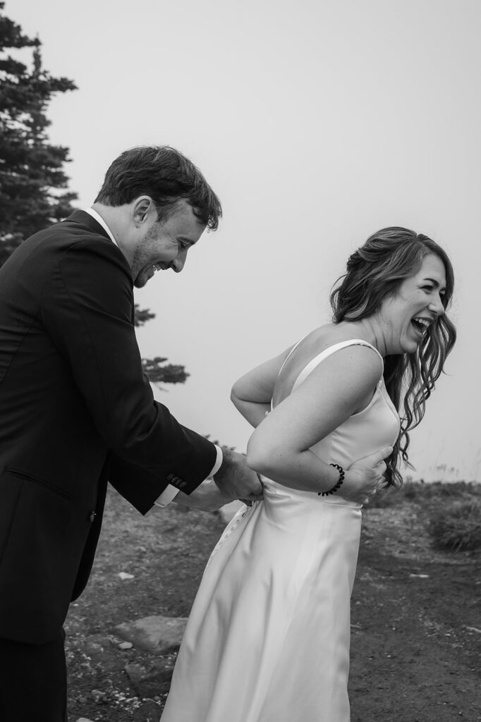 Bride and groom getting ready together on a foggy mountain trail at Mt. Rainier