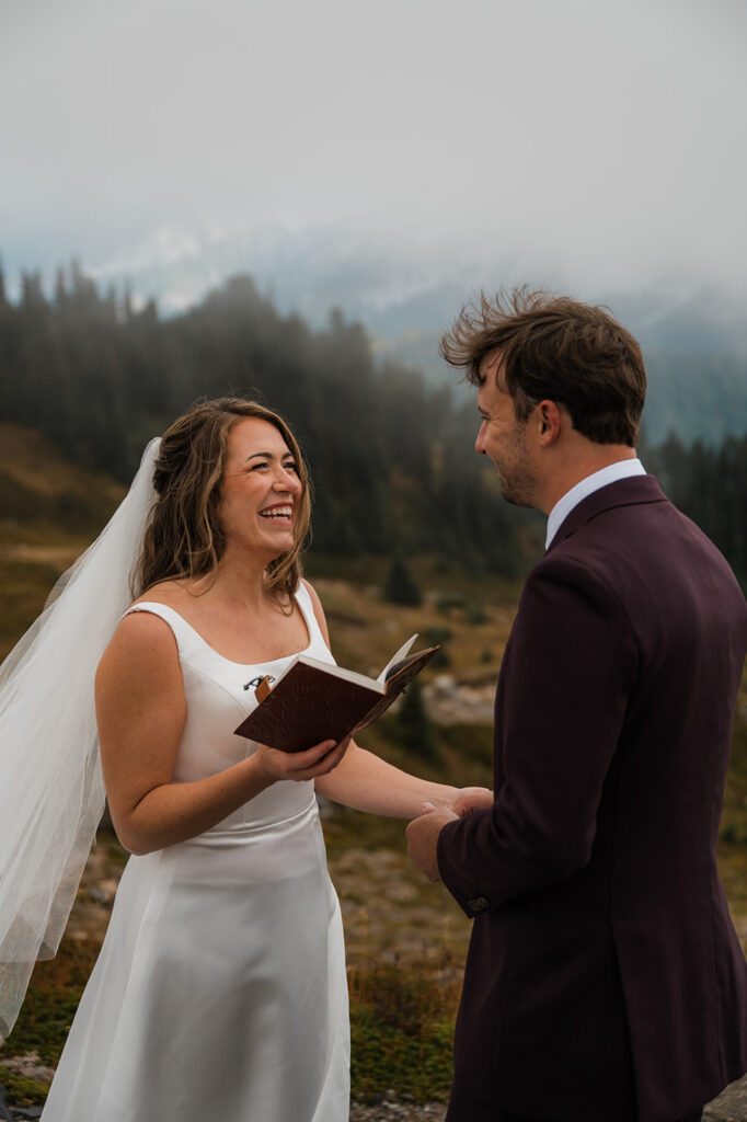 Elopement at Mt. Rainier on Skyline Trail with couple reading vows in October fog