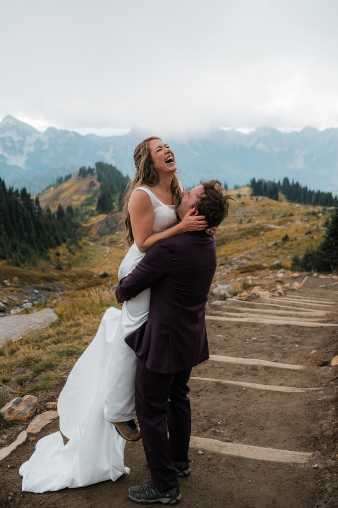Couple laughing together during windy and foggy elopement at Mt. Rainier
