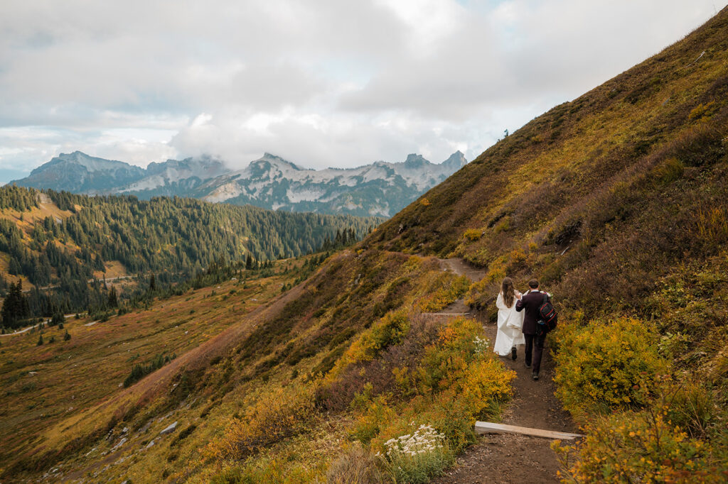 Couple hiking through alpine terrain during fall elopement at Mt. Rainier