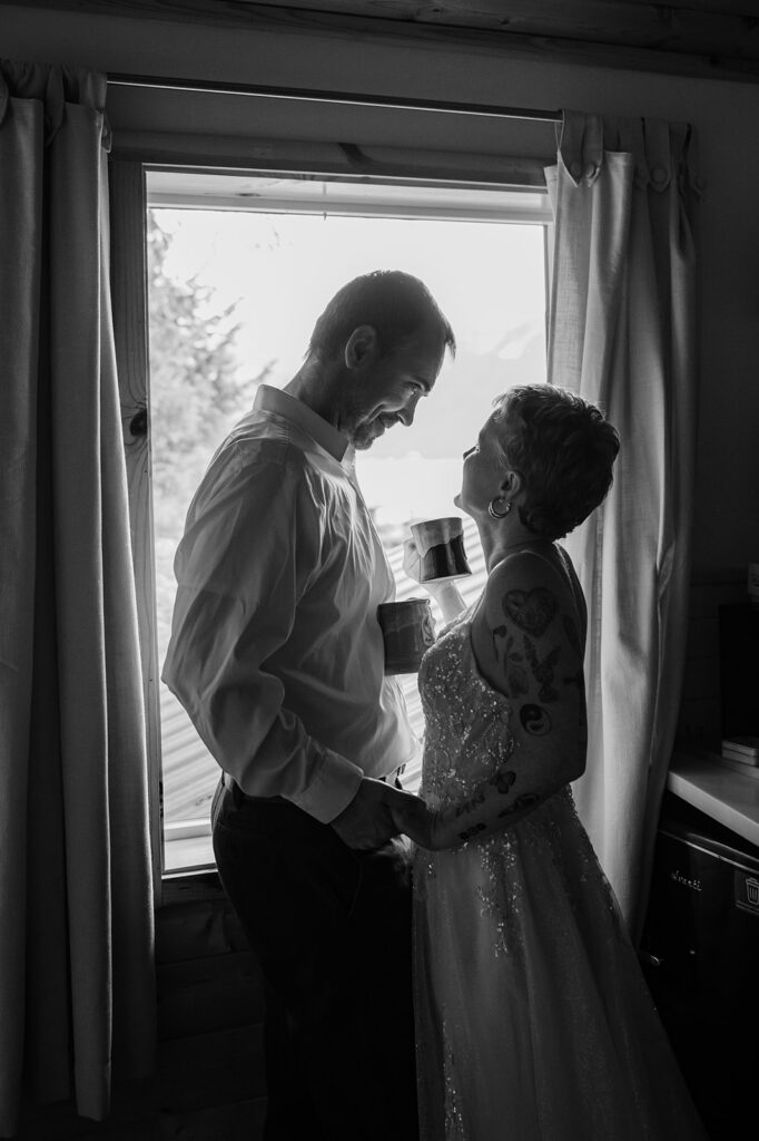 Hannah and Thad drinking coffee together in their cabin at Salted Roots in Seward Alaska