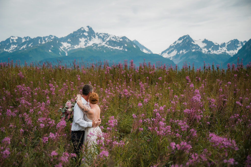 Couple walking through fireweed field during peak bloom in Seward Alaska